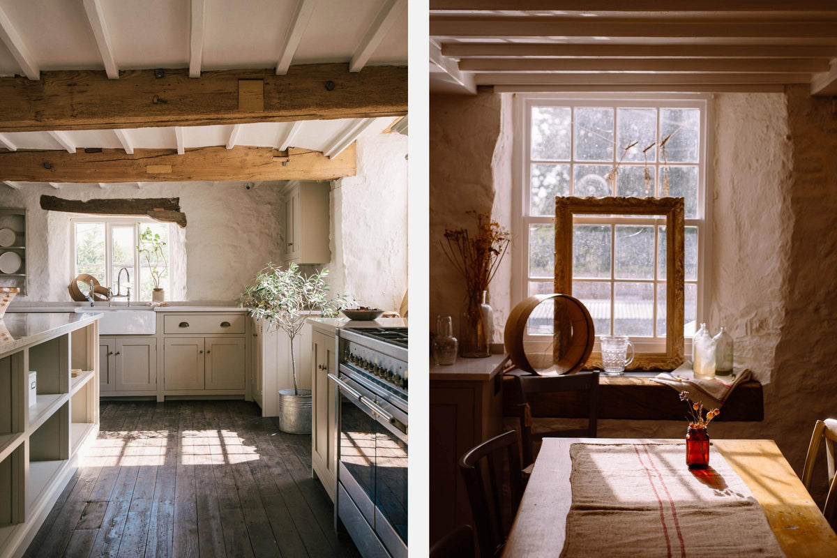 A sink run in a simple English farmhouse kitchen at Nacoco’s headquarters, Nacoco Mill. Low-exposed wooden beams, antique furnitures, and worn floorboards create a rustic atmosphere, while textured off-white walls add charm.